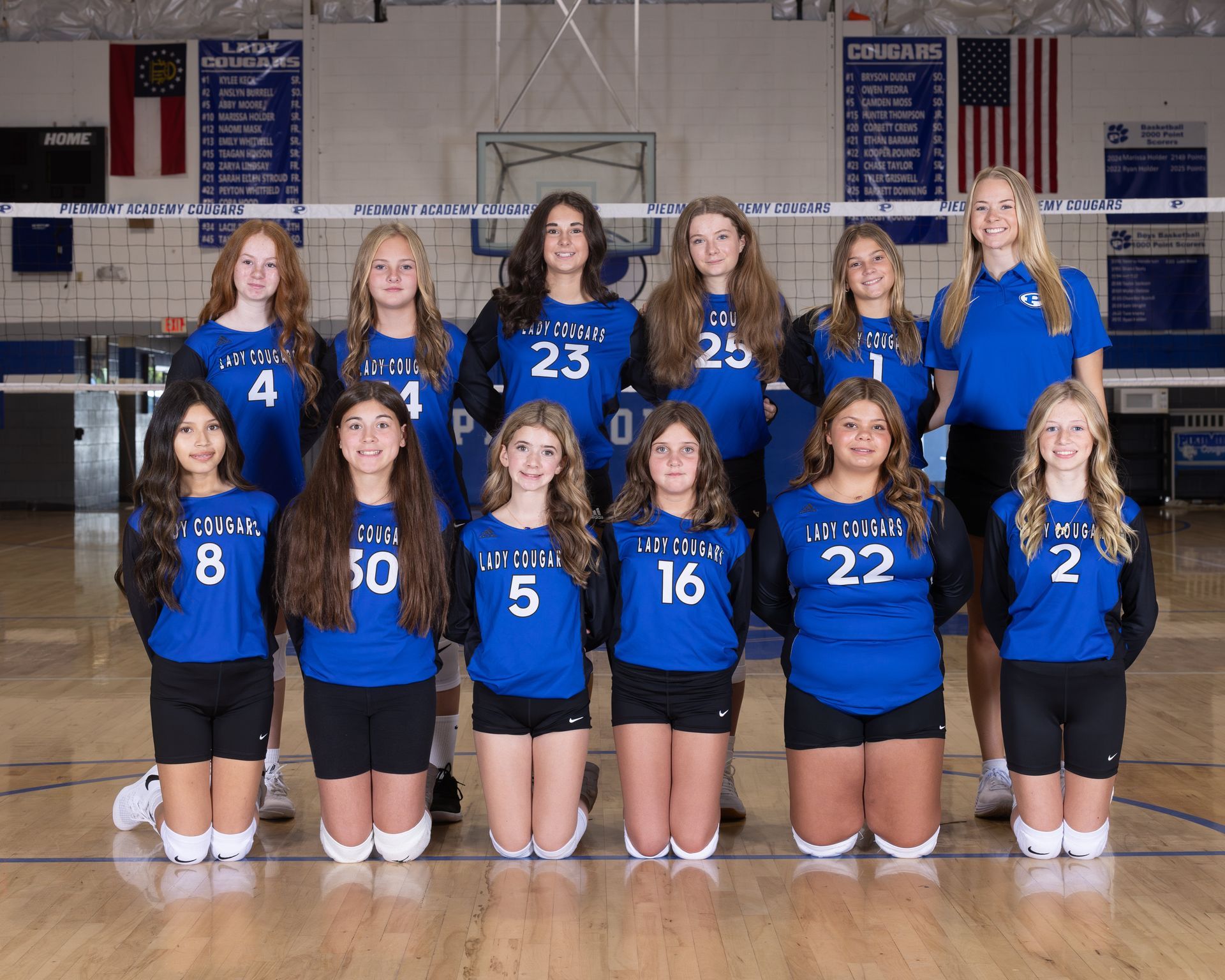 A group of volleyball players are posing for a team photo.