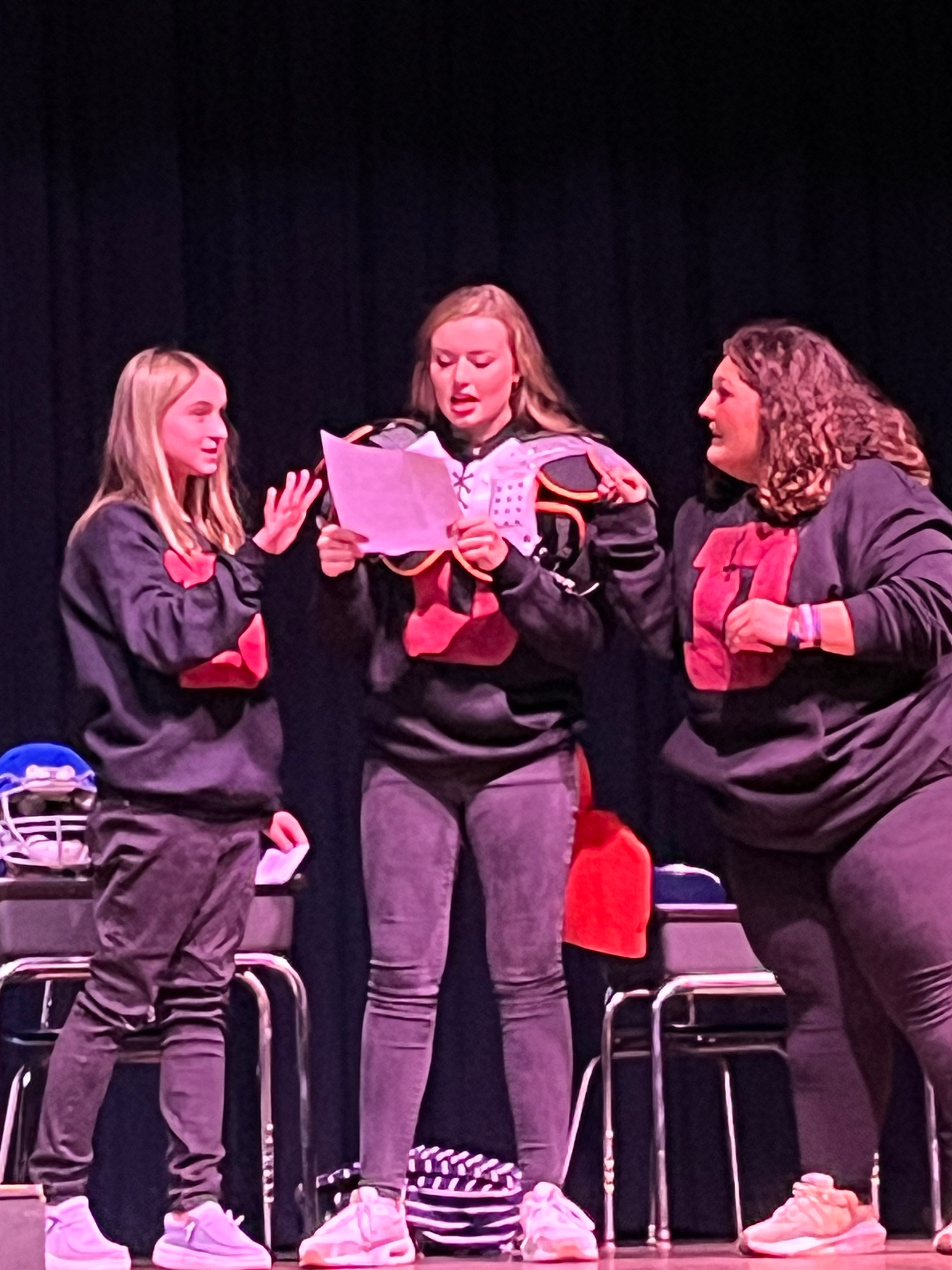 A group of people are posing for a picture in front of a sign that says applause.