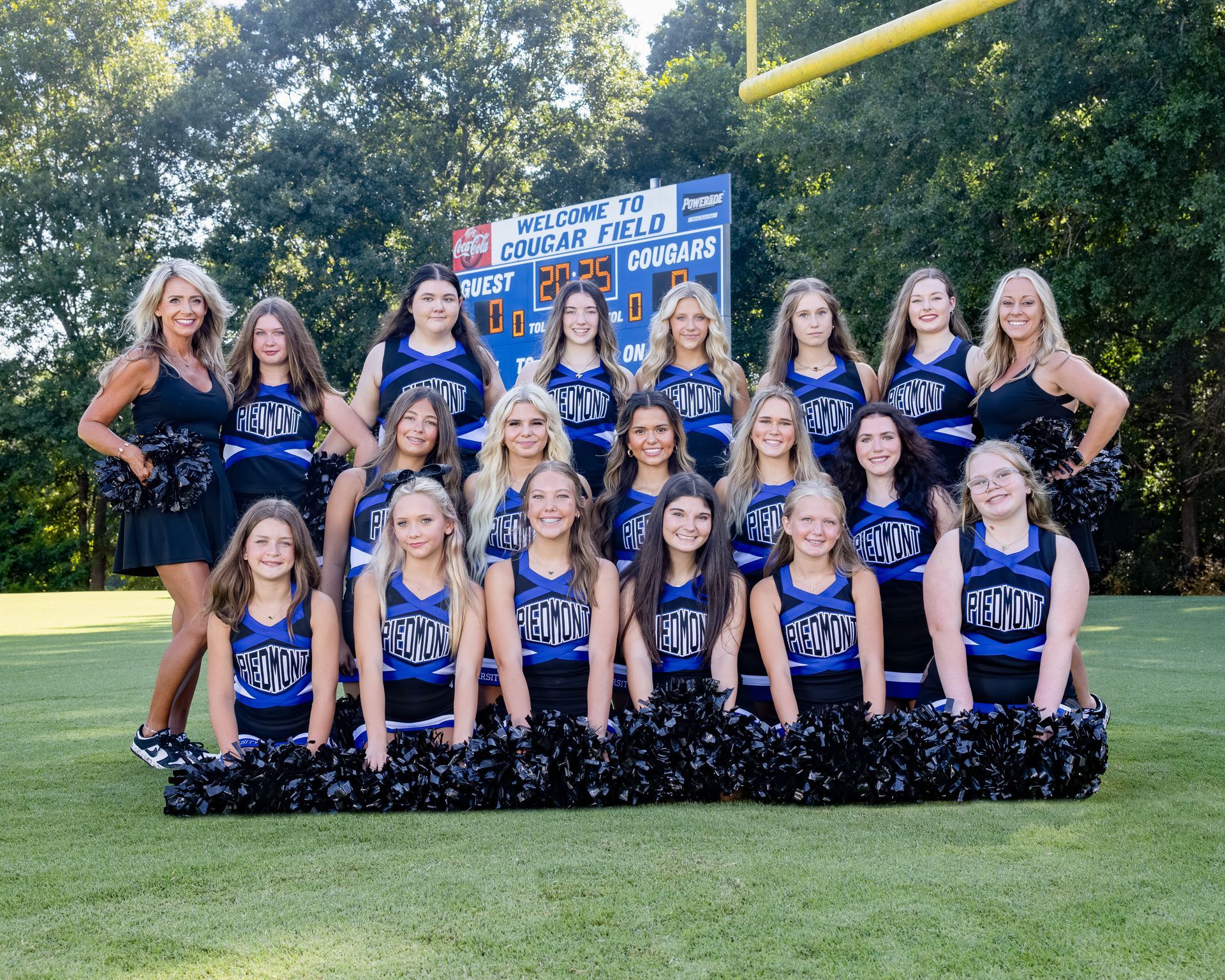 A group of cheerleaders are posing for a picture.