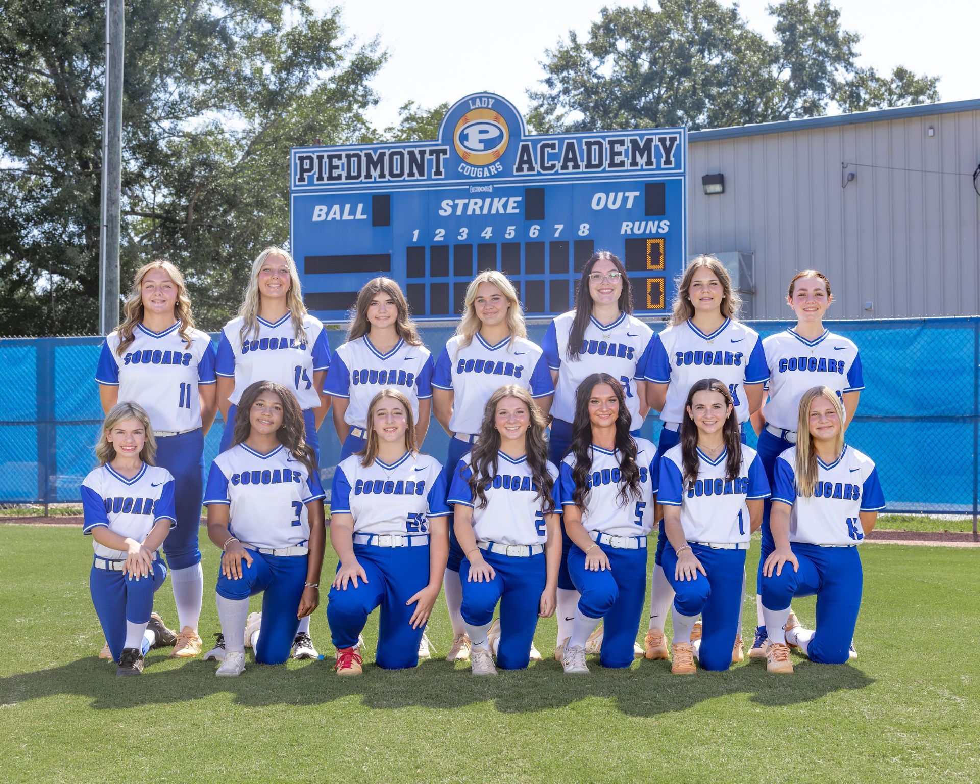 The piedmont softball team is posing for a team photo.