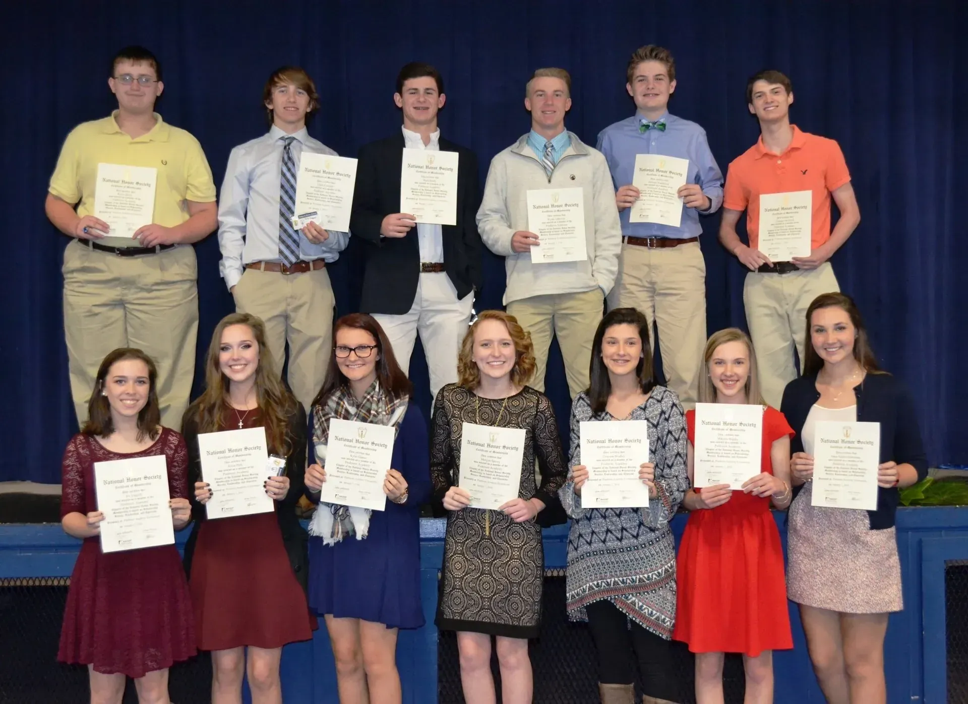 A group of young people are posing for a picture while holding certificates.