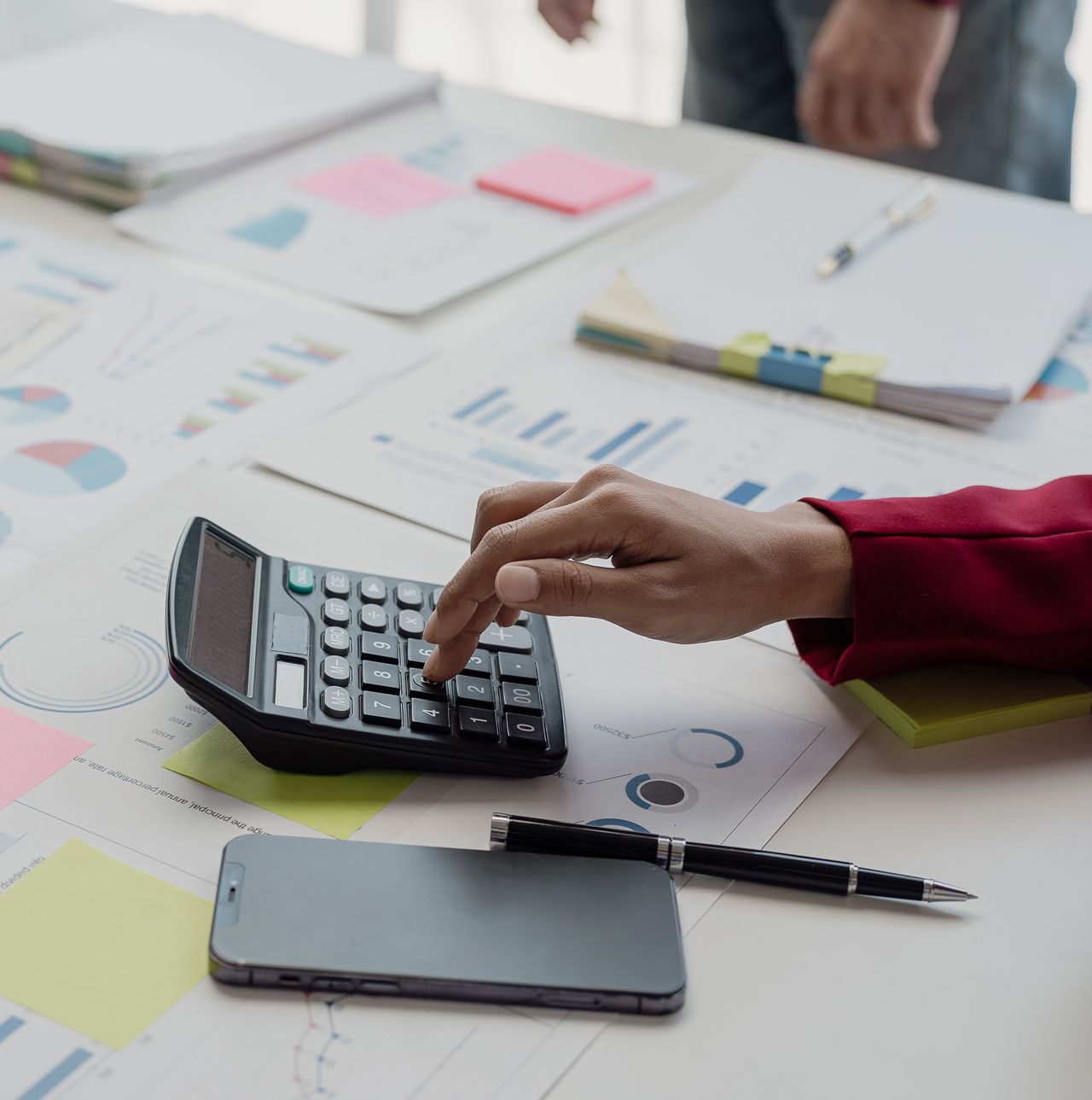 A person is using a calculator on a table