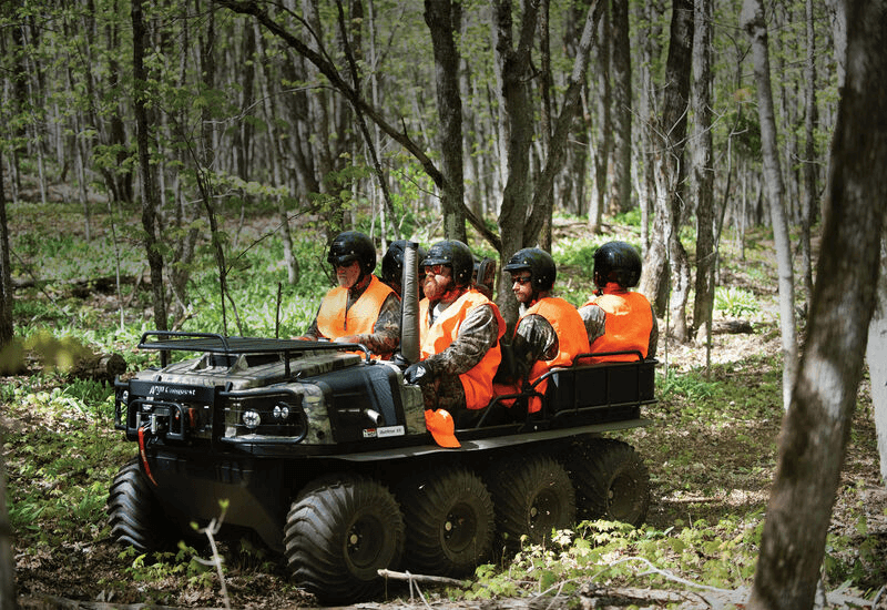 Argo Conquest Commercial XTV with 6 people riding with orange safety vests.