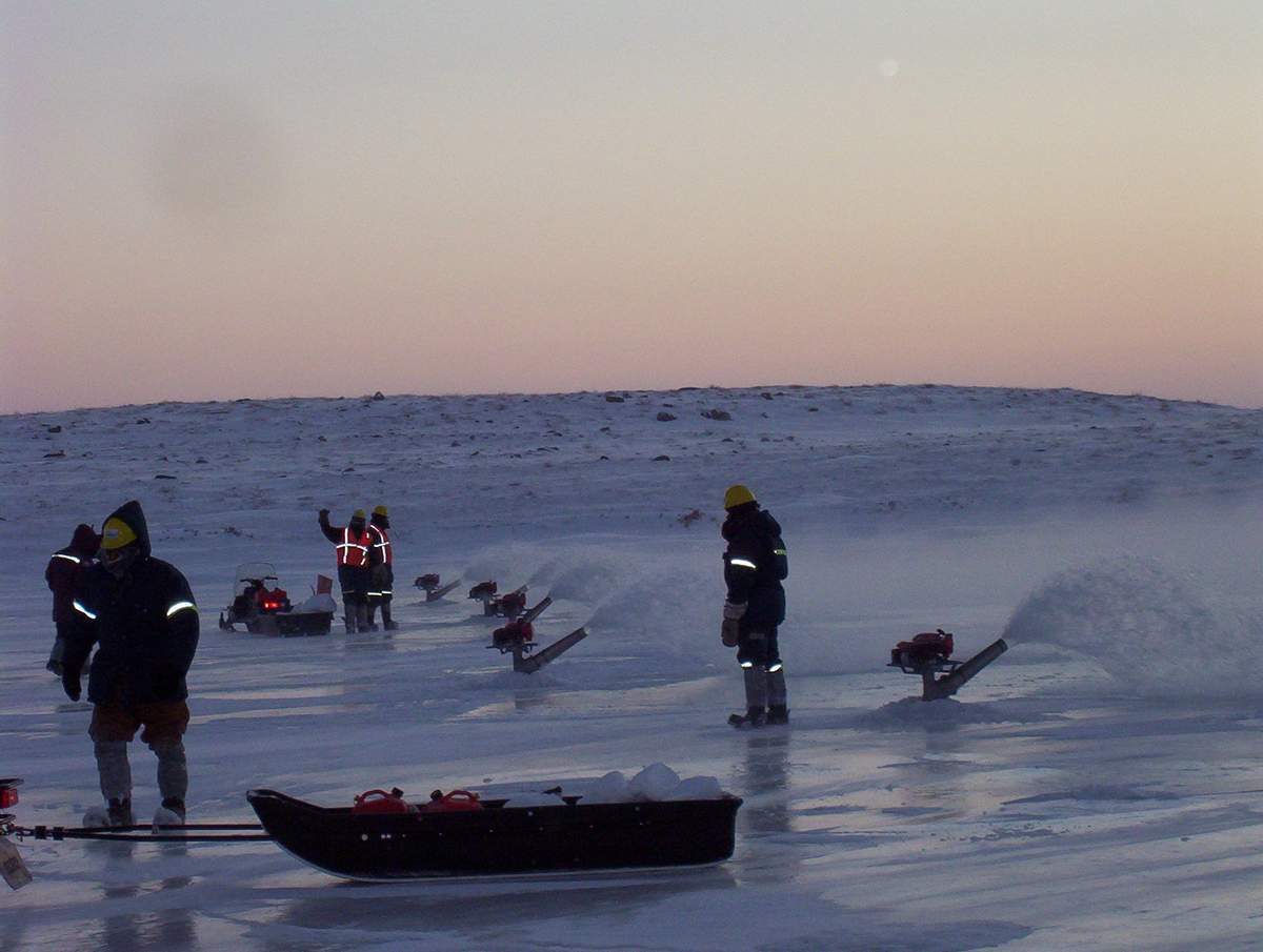Workers flooding a Ice Road with Big Ice flood pump.