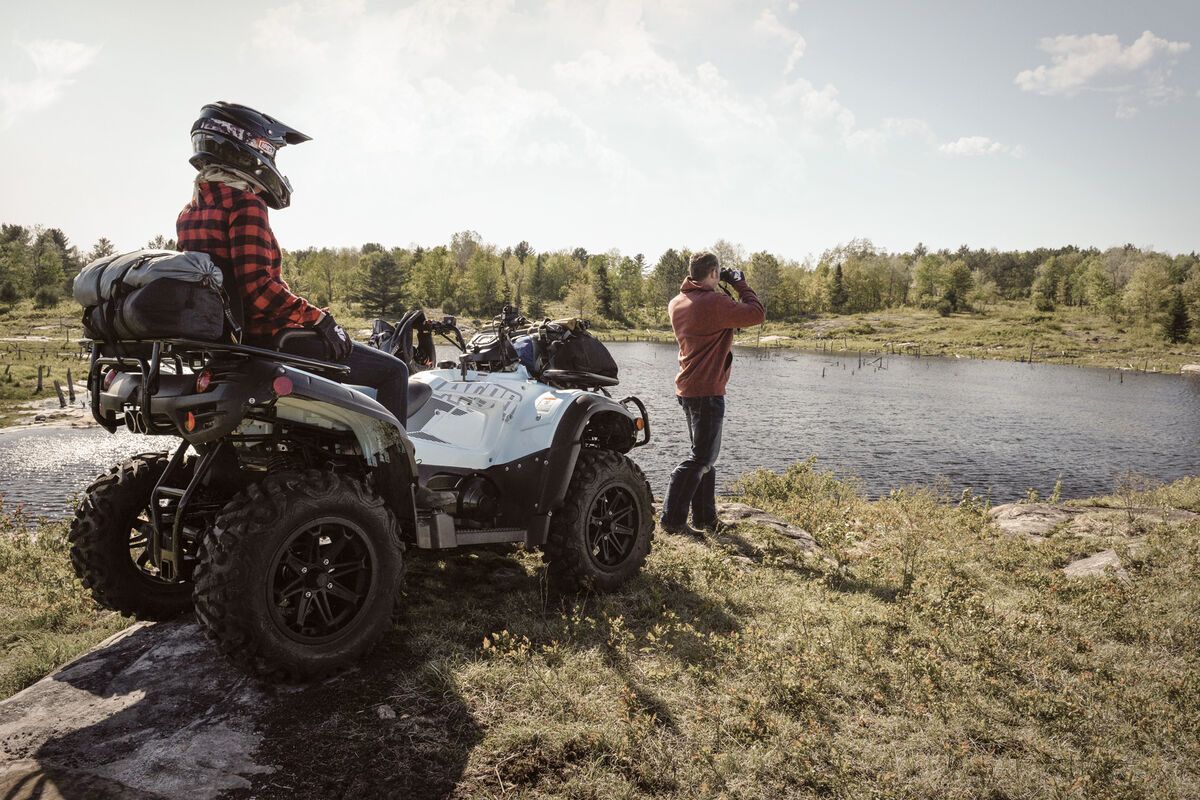 Two people looking over the lake beside their ATV.