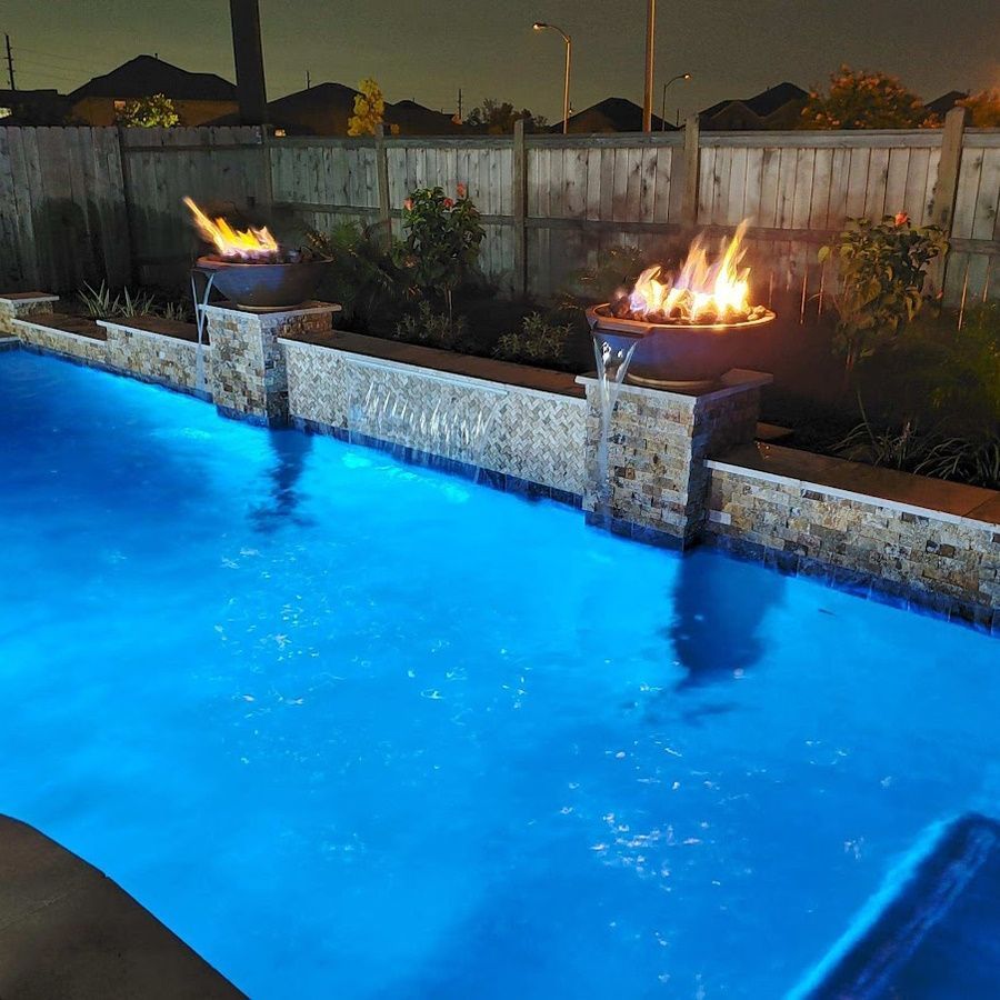 A large waterfall is in the middle of a building surrounded by trees.