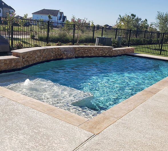 A large swimming pool with a fence around it and a house in the background.