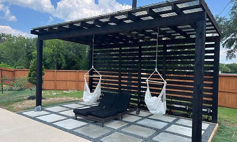 A pergola with chairs and hammocks hanging from it in a backyard.