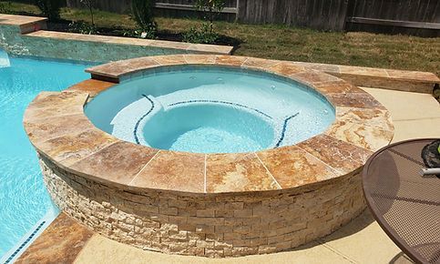 A hot tub is sitting next to a swimming pool.