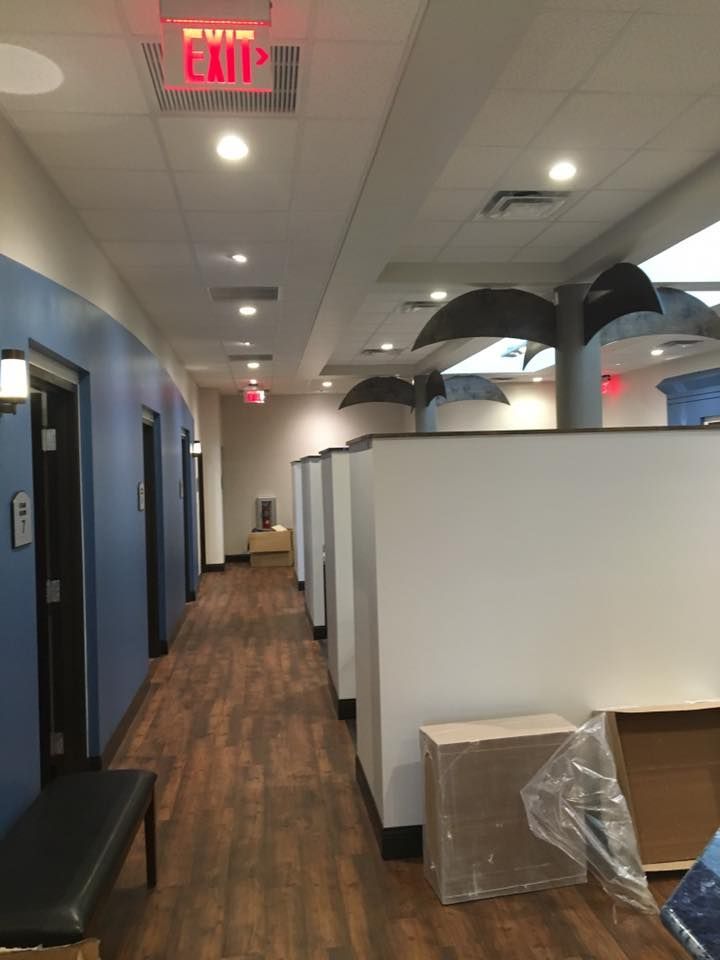 Hallway with blue and white walls, wood-look flooring, and exit signs.