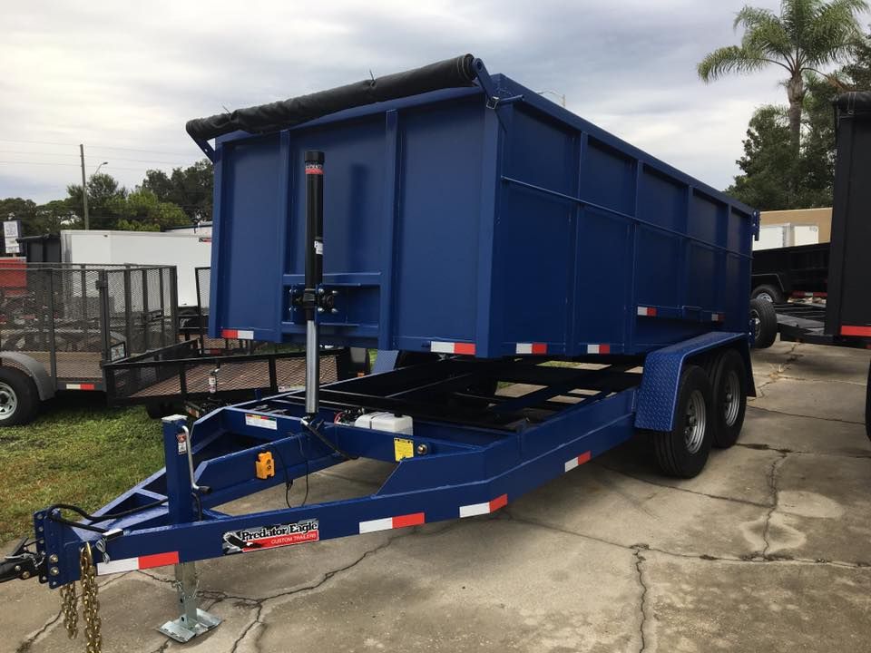 Blue dump trailer on a sunny day.