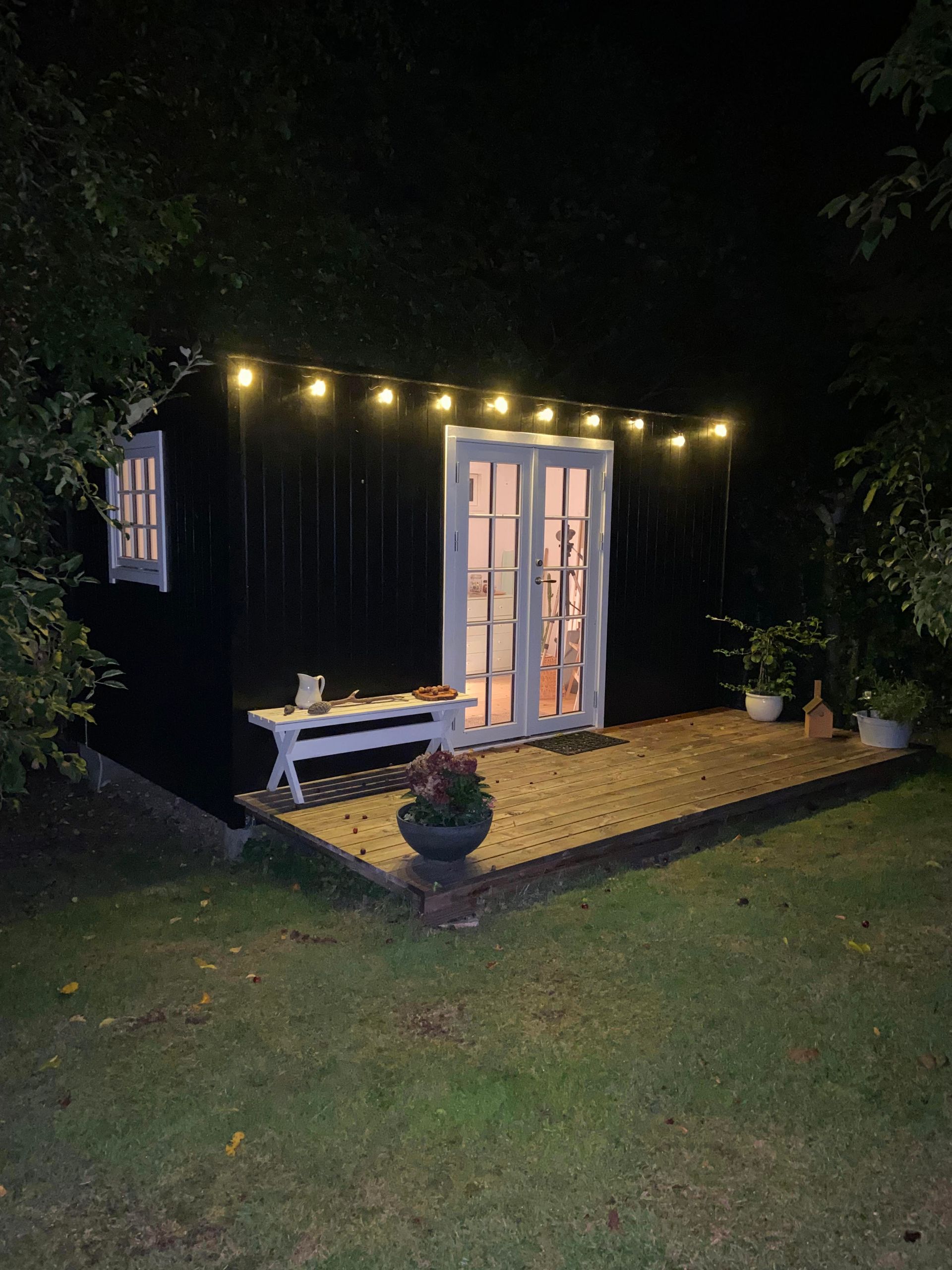 Et skur med franske døre er oplyst om natten.