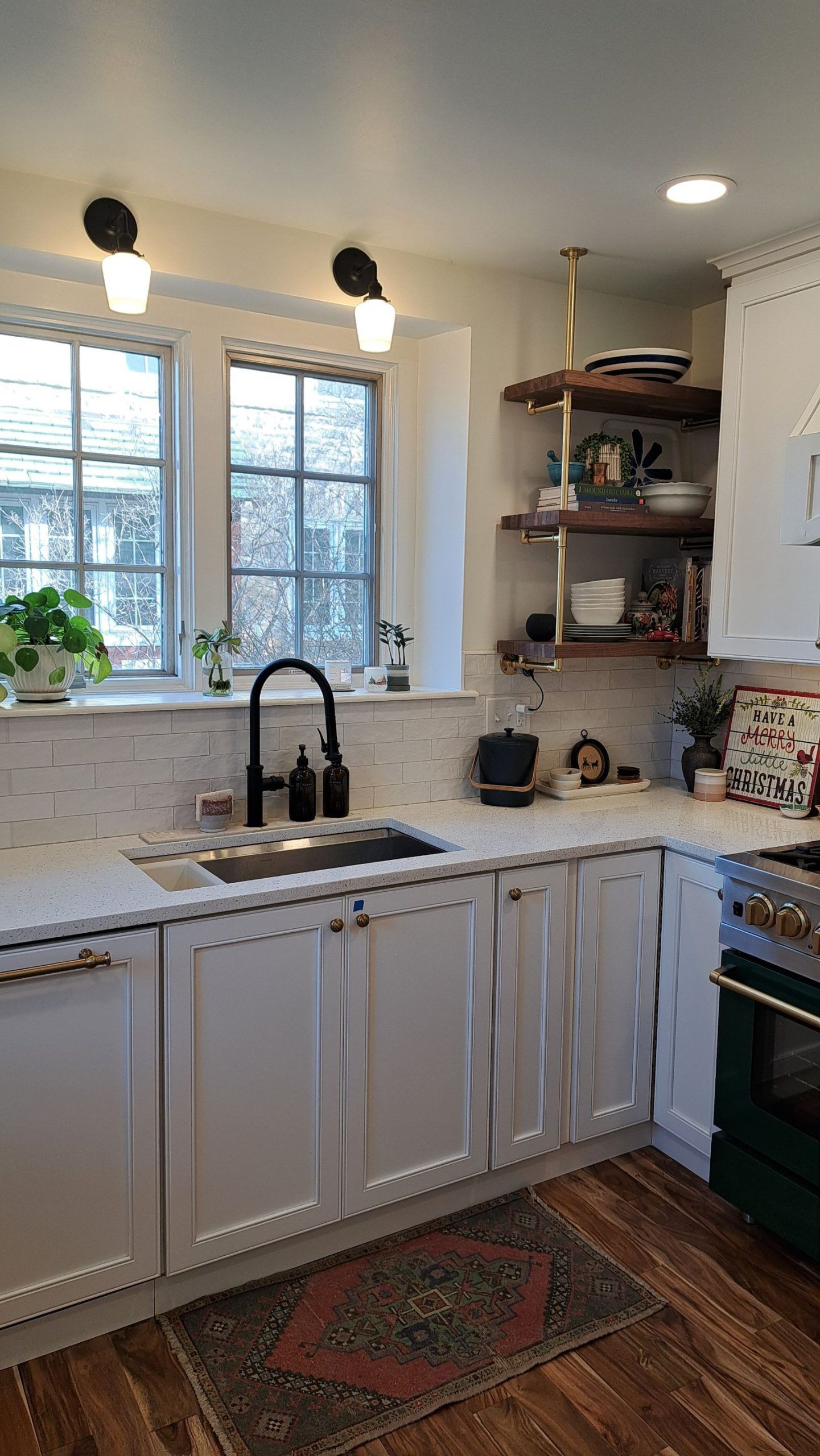 Kitchen with white cabinets, marble countertop, black faucet, and open shelving.