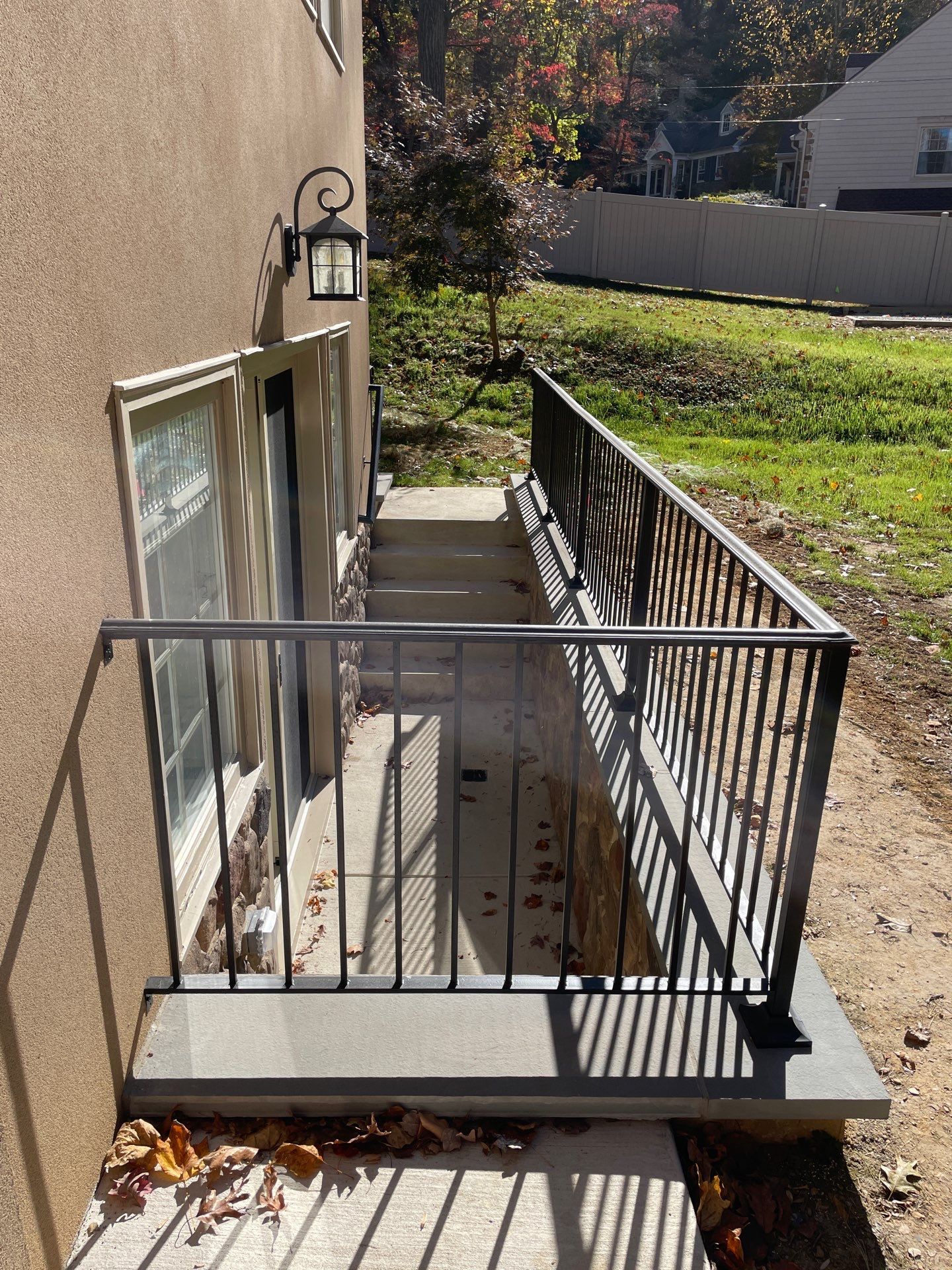 Exterior basement access with stairs, metal railings, and a small window.