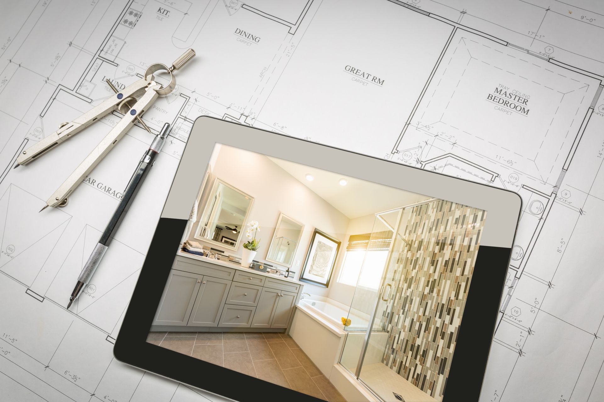 Tablet displaying a bathroom design concept placed over architectural floor plans.