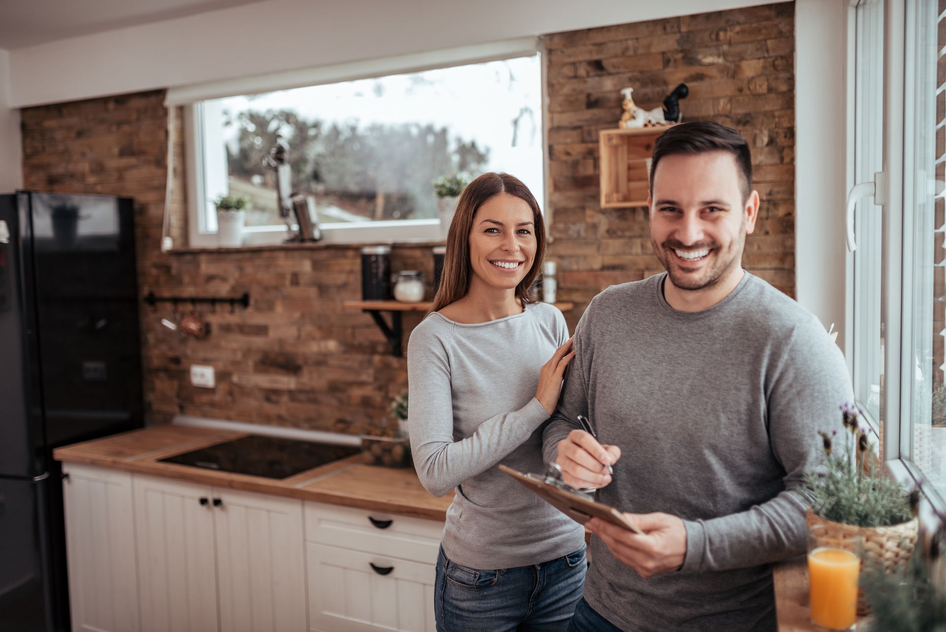 Portrait of a happy couple remodeling their kitchen and holding a blueprint.