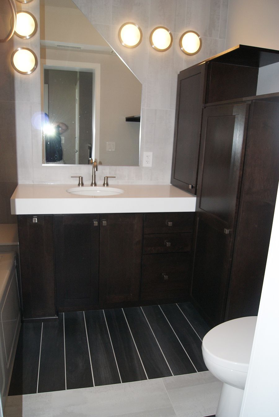 Bathroom with dark wood vanity, white countertop, and tiled floor.