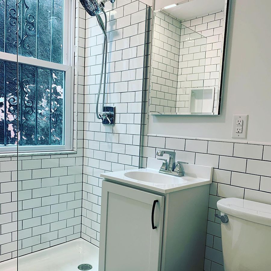 Small bathroom with white subway tile, a sink, and a shower with glass enclosure.