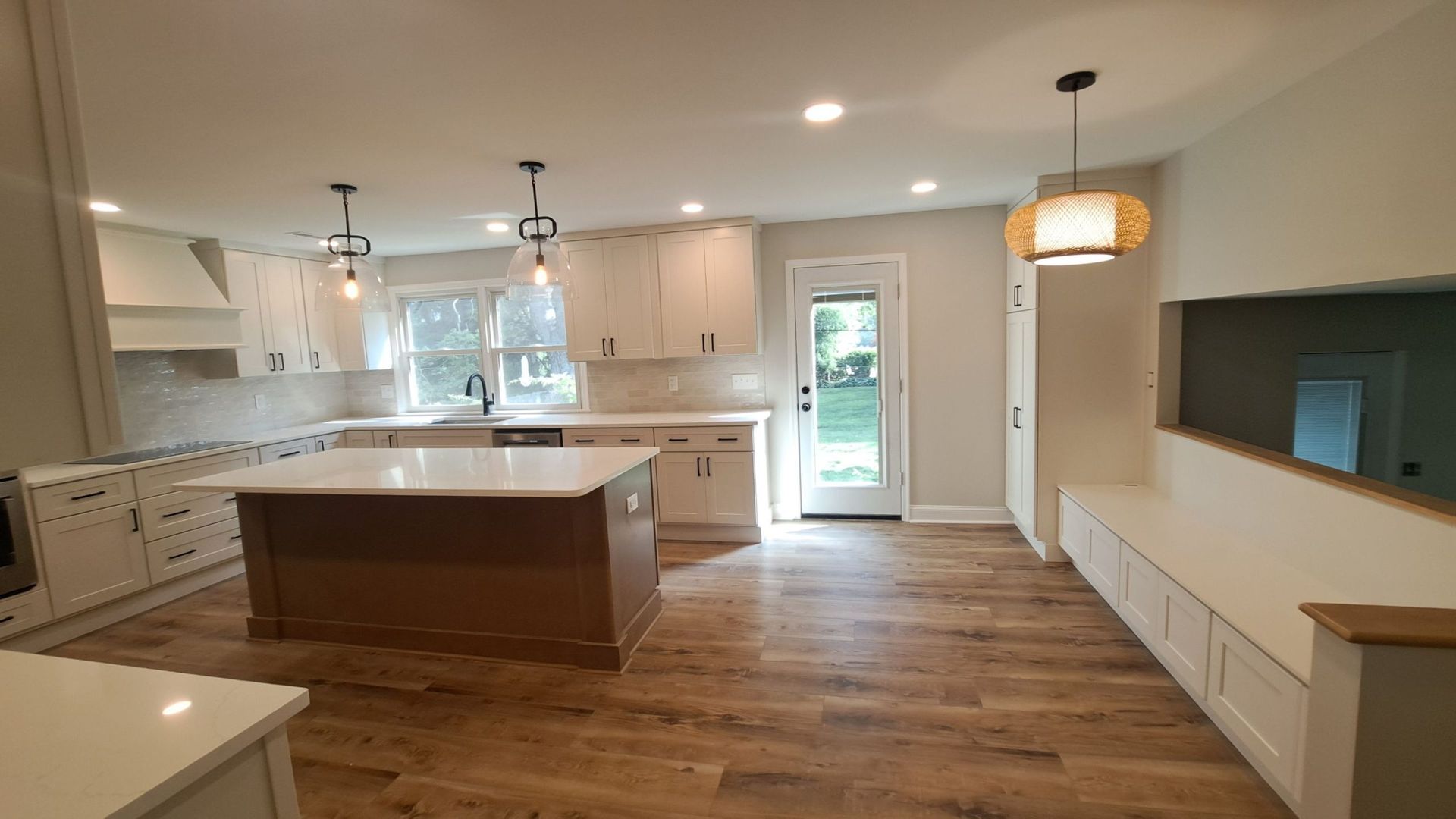 Newly renovated kitchen with white cabinets, island, and wooden floors.