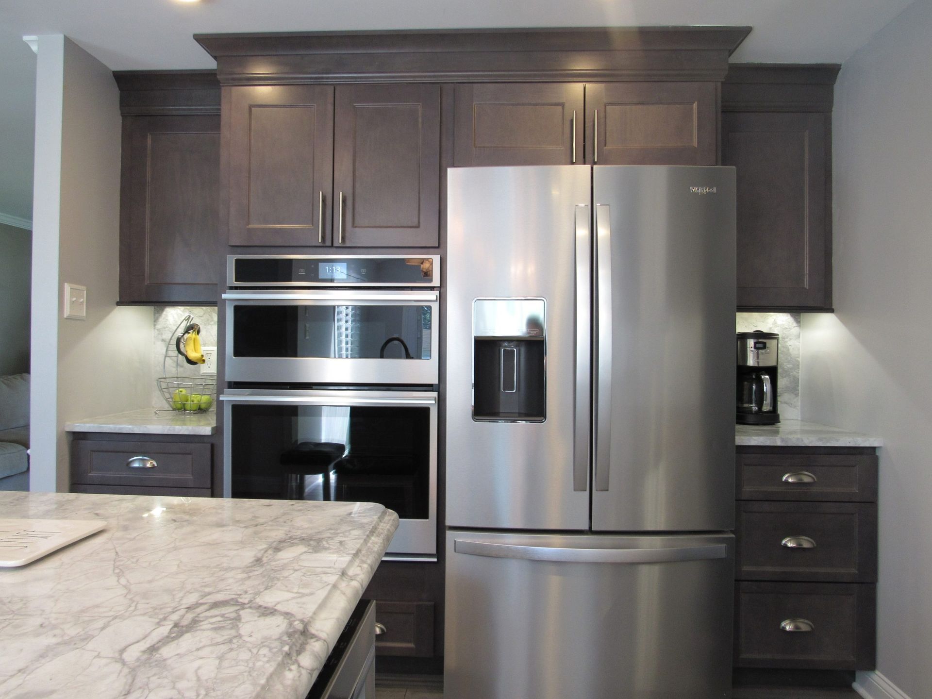Kitchen with dark cabinets, stainless steel appliances, granite countertop, and recessed lighting.