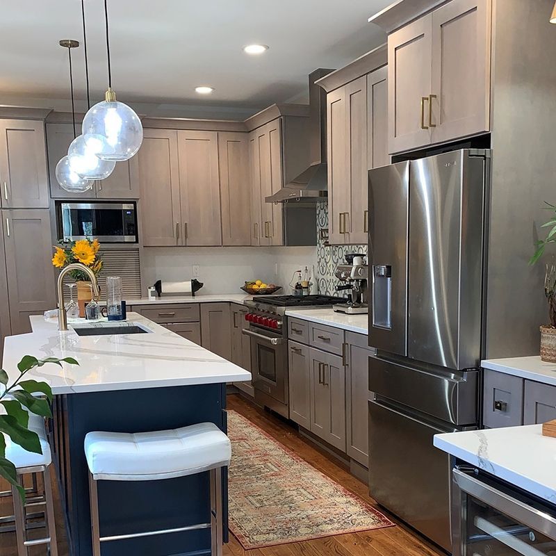 Red kitchen cabinets with granite countertops. Kitchen island has granite. Beige walls.