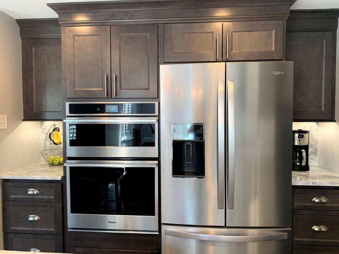 Kitchen with gray cabinets, stainless steel appliances, and built-in double oven.