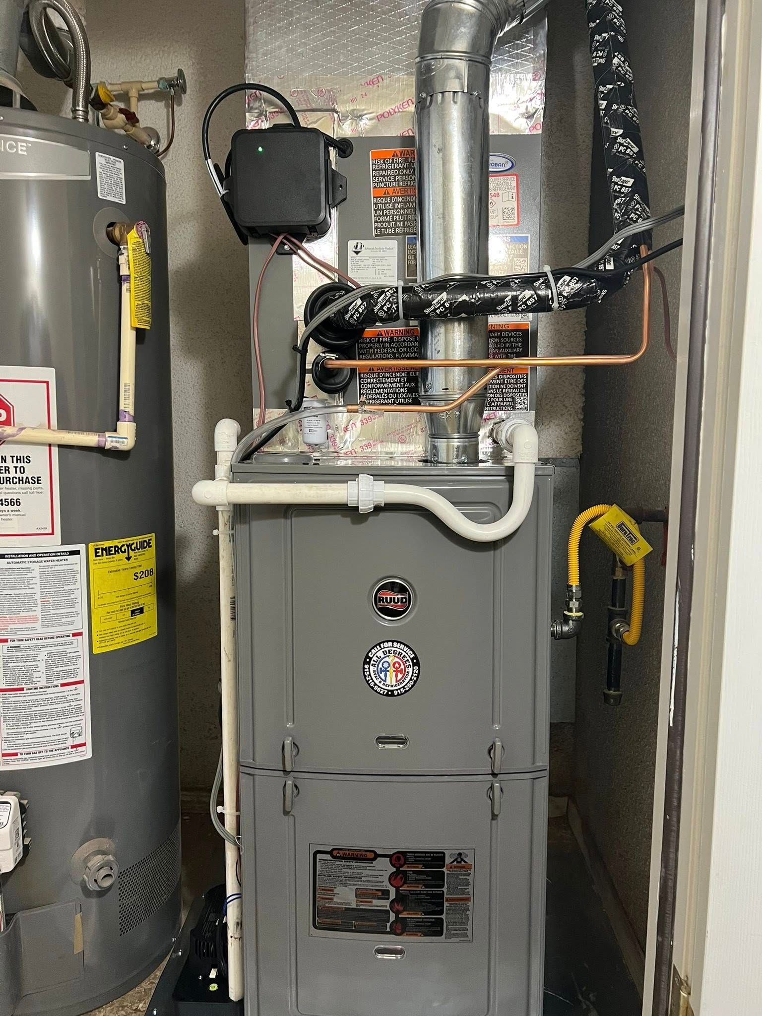 Gray furnace and hot water heater in a utility room.