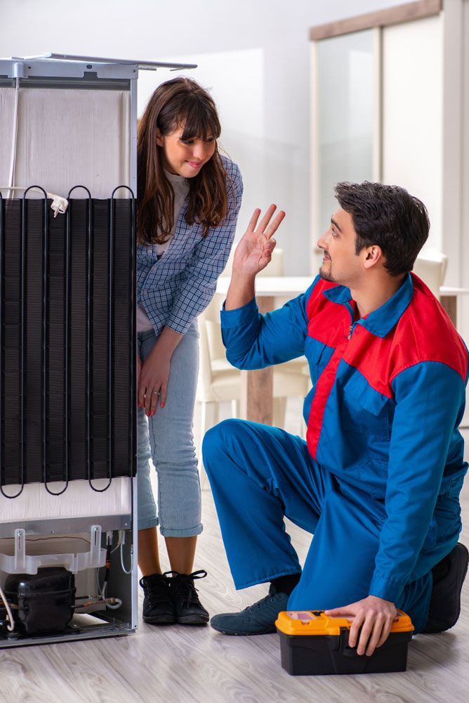 Electrician and Client next to Refrigerator — CH Electrics in Central Queensland, QLD