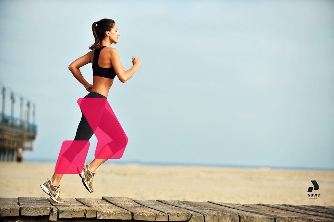 A woman is running on a pier on the beach.