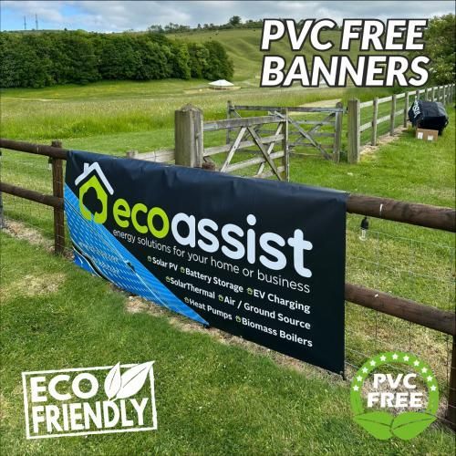 A pvc free banner is hanging on a wooden fence in a field.