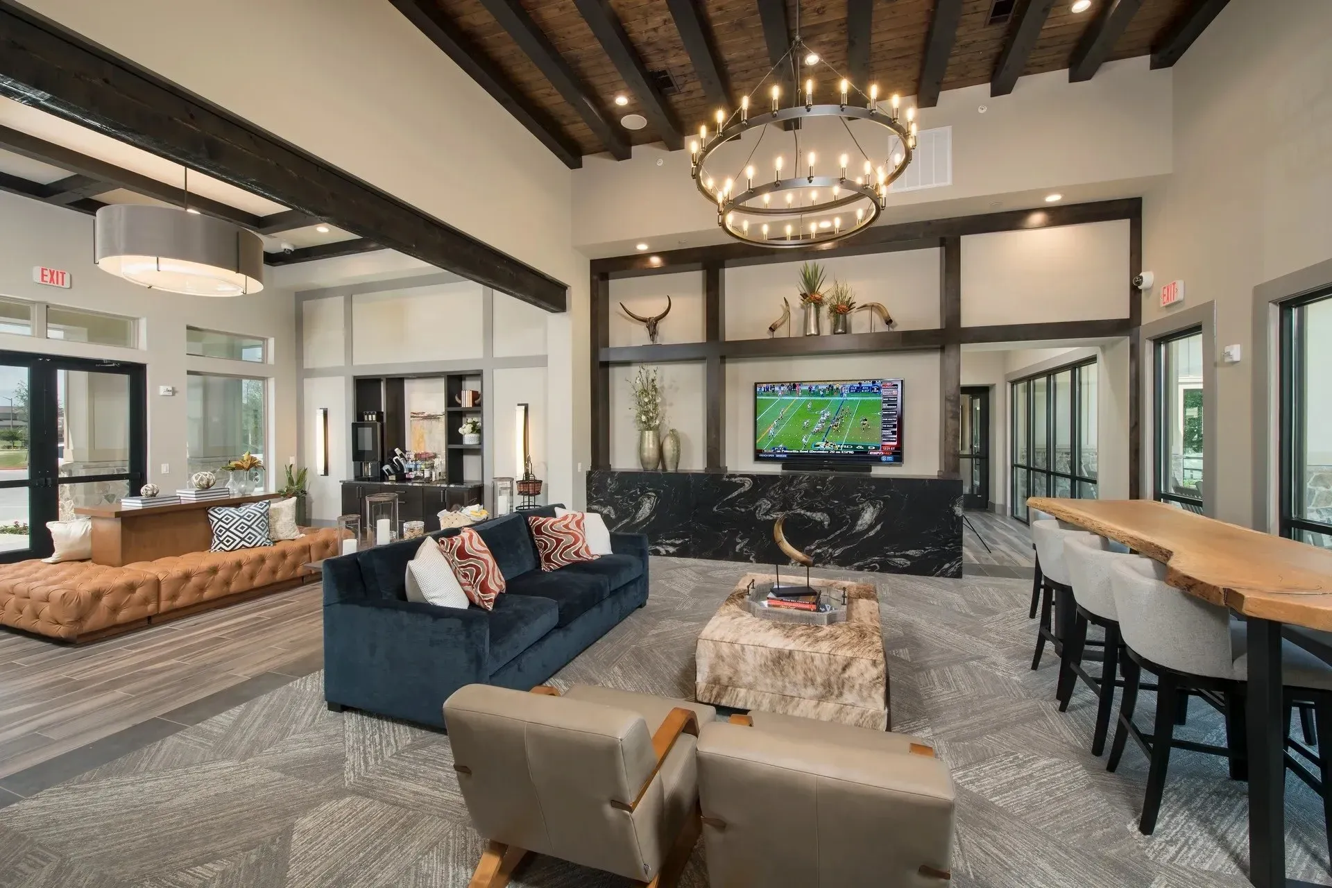 Modern community lounge with sofas, a TV, and a dining table.