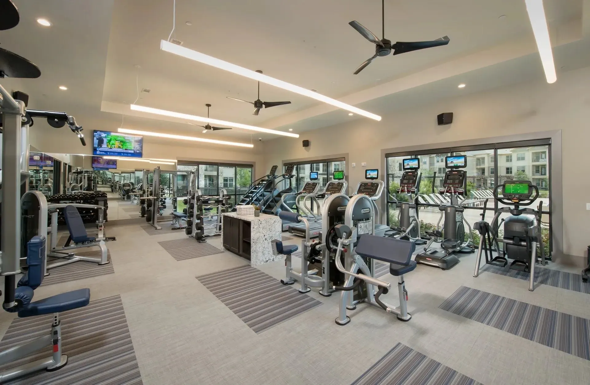 Modern gym with exercise equipment and large windows