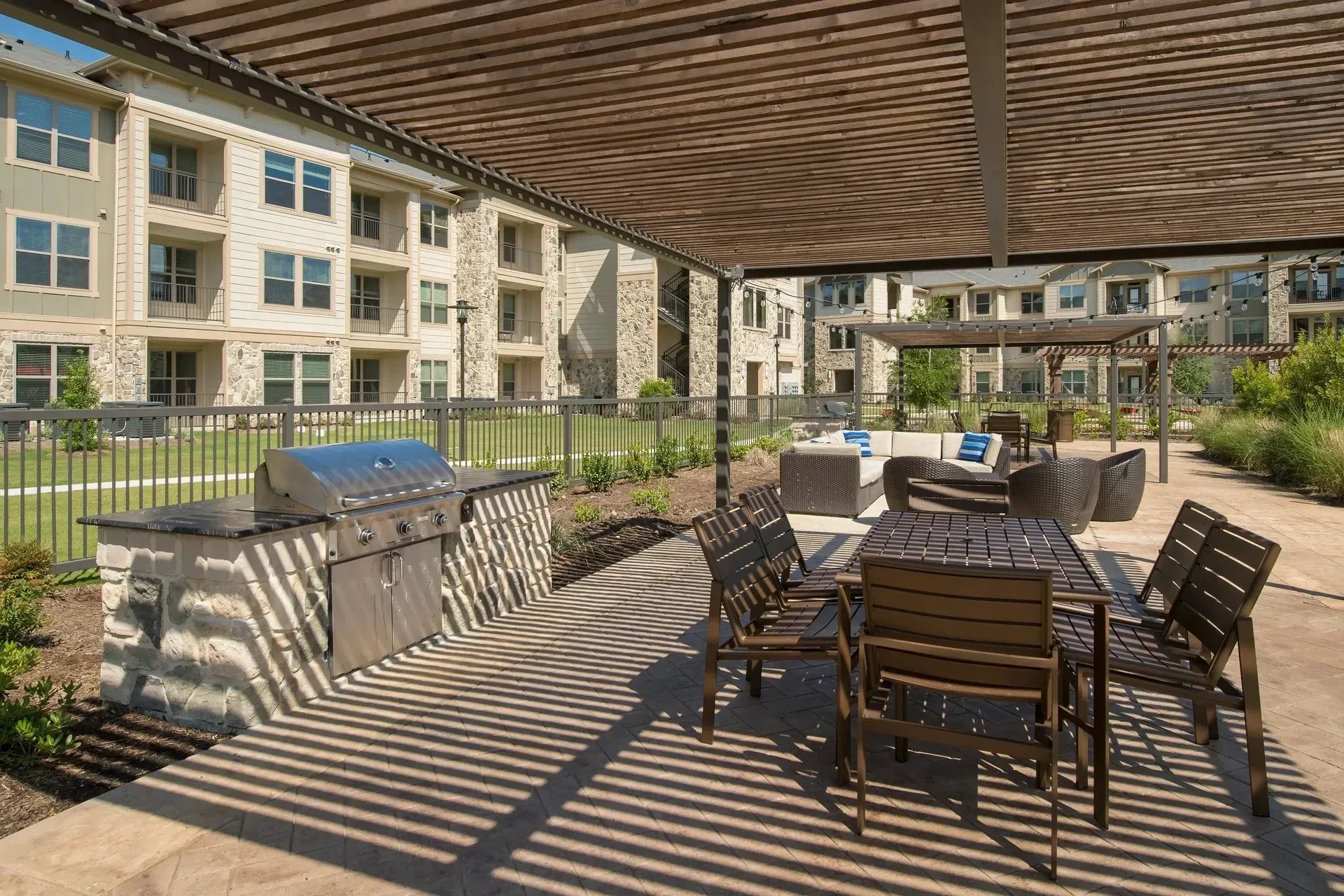 Outdoor grilling area with seating and apartment buildings in the background