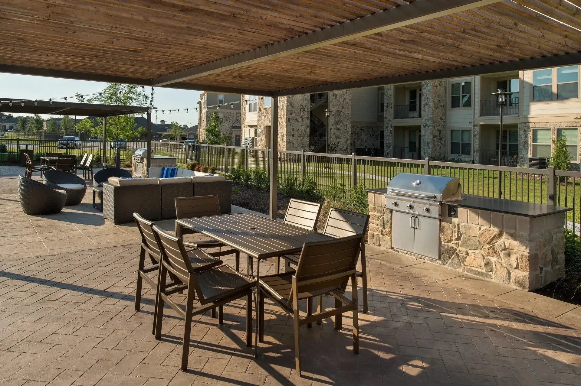 Outdoor seating area with a grill and stone backdrop