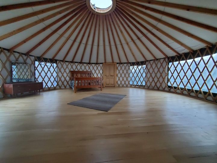 Yurt interior with bed door and side table in New Zealand for Glamping