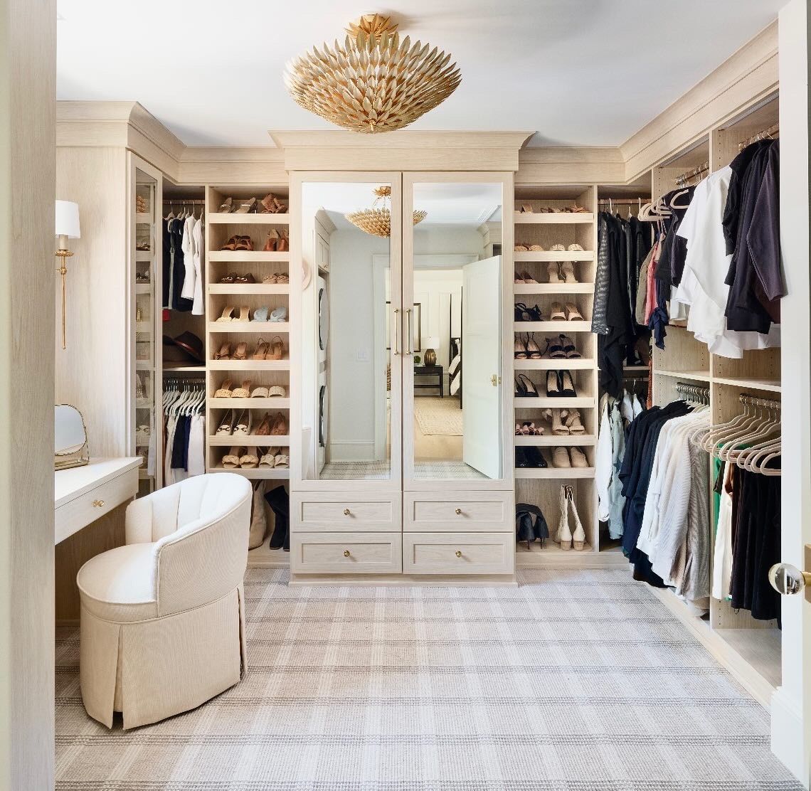 A large walk in closet with lots of clothes and shoes