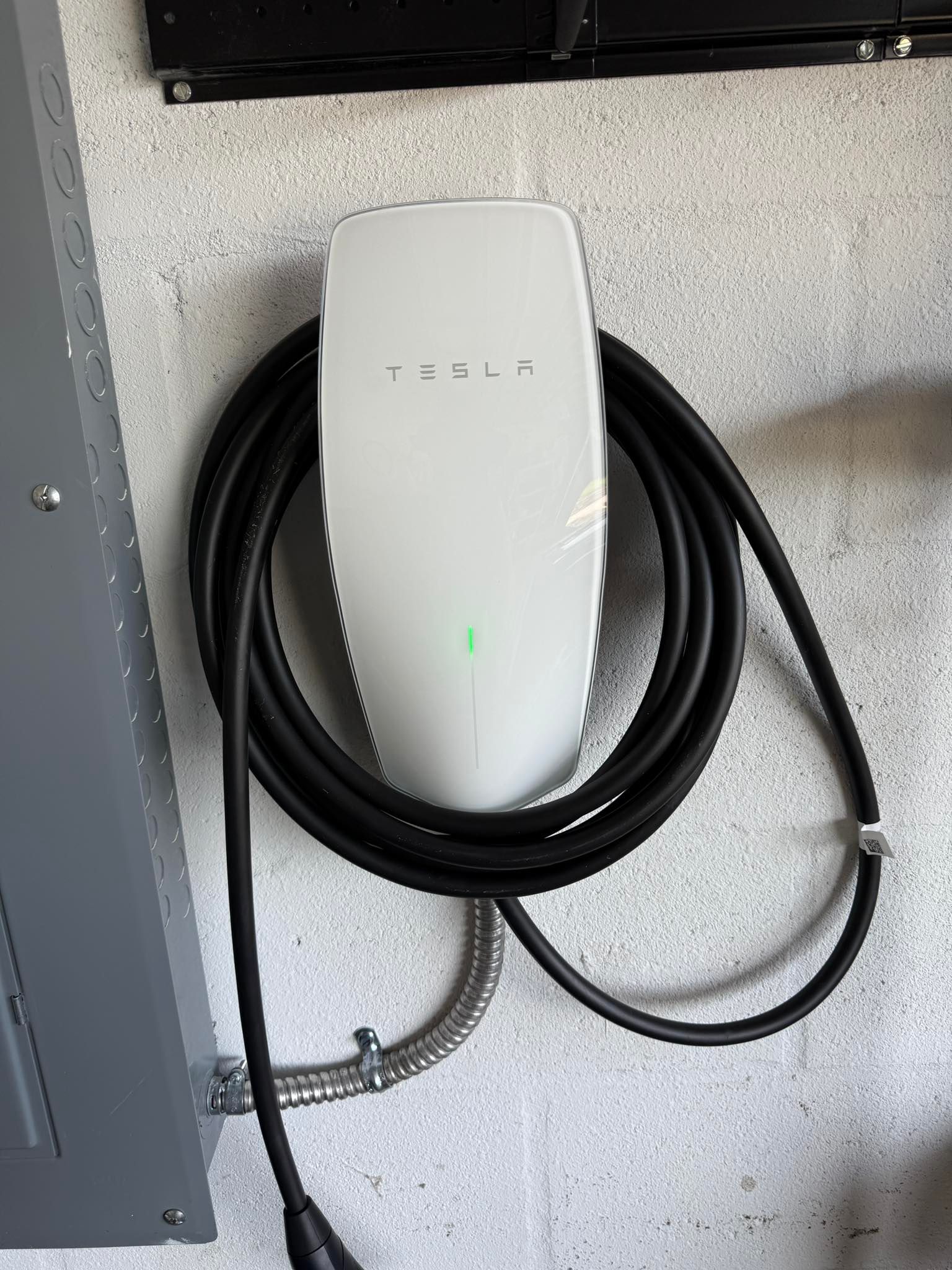 Woman in straw hat smiles, holding wine glass near a lake.