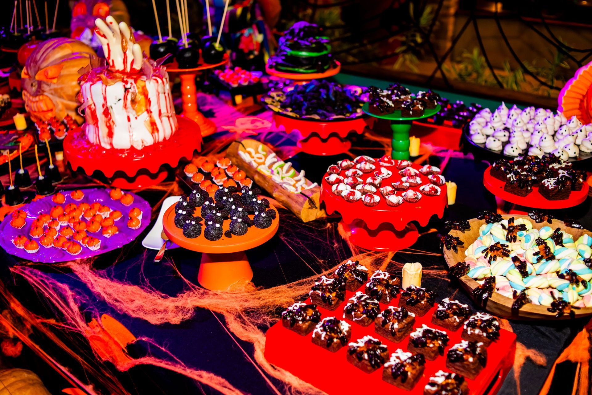 Uma mesa coberta com uma variedade de sobremesas para uma festa de Halloween.