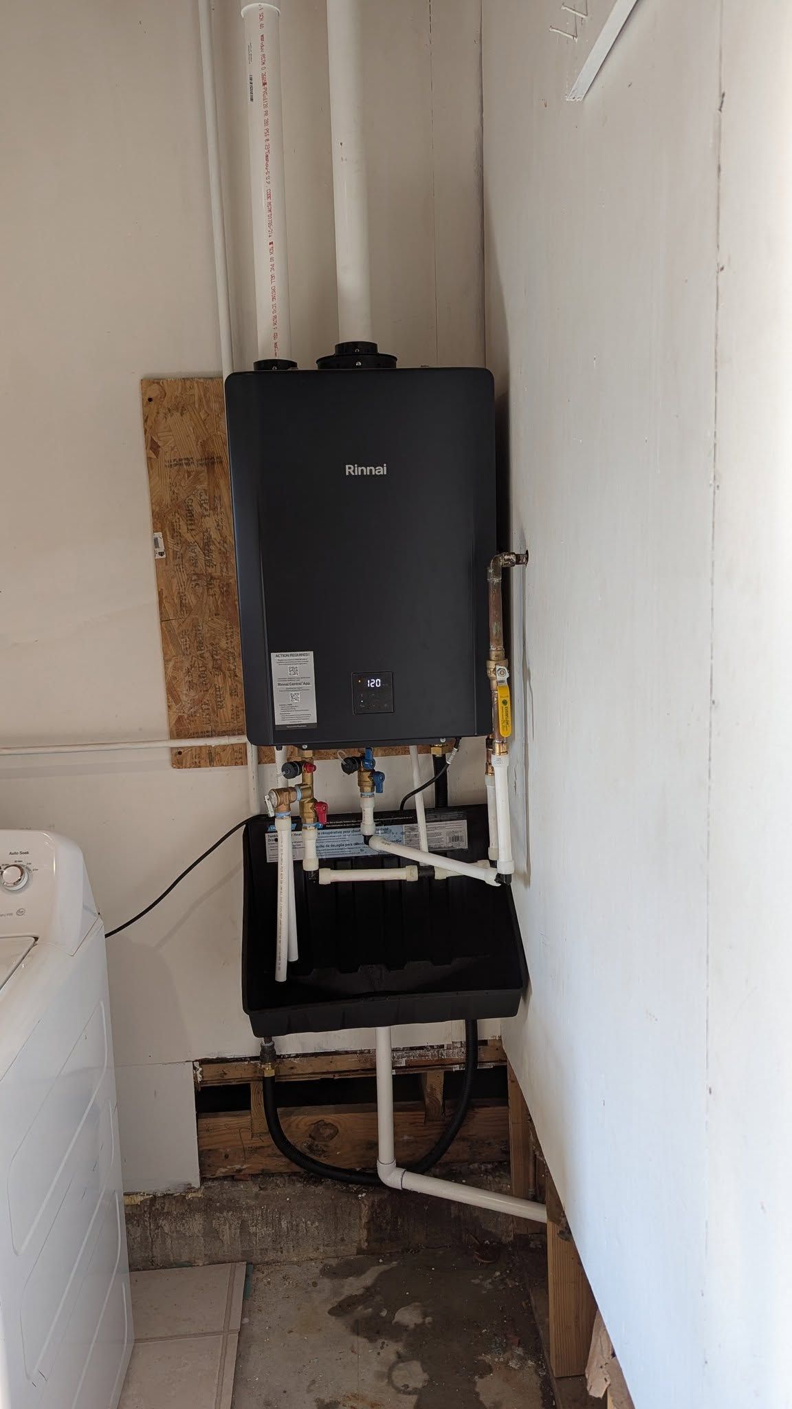Tankless water heater unit mounted on a wall, with plumbing connections visible.