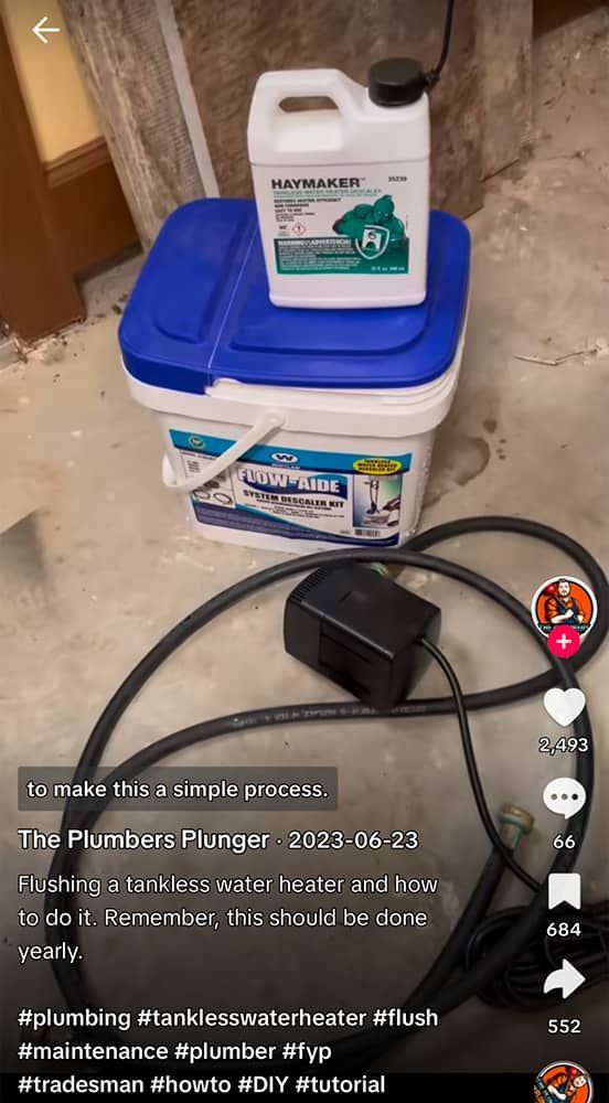 Plumbing supplies: bucket, chemical, electric pump, and hose on a concrete floor.