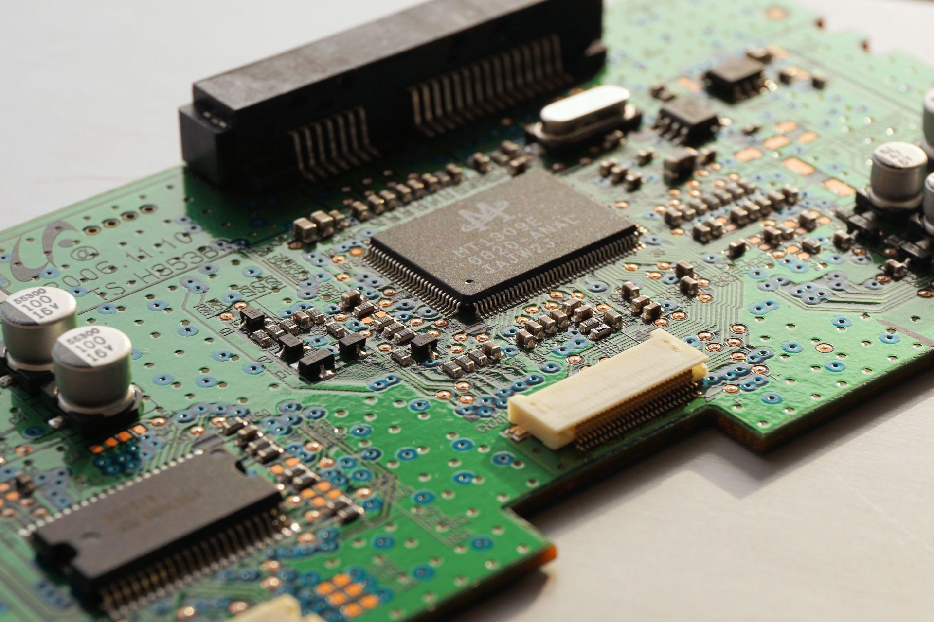Close-up of a green circuit board with chips, connectors, and electronic components