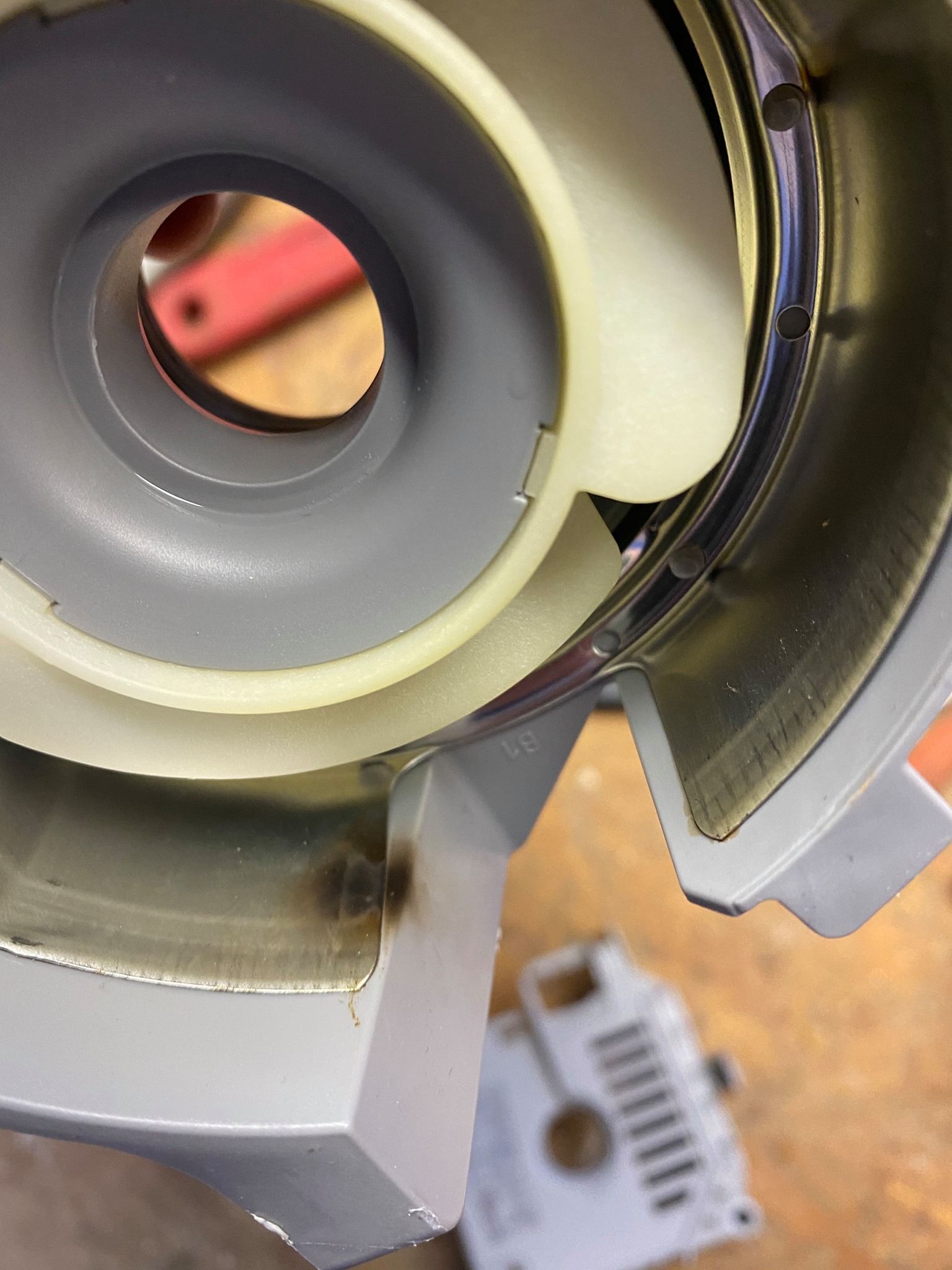 Close-up of a machine's interior. A central, circular structure with blades sits within a metal housing.