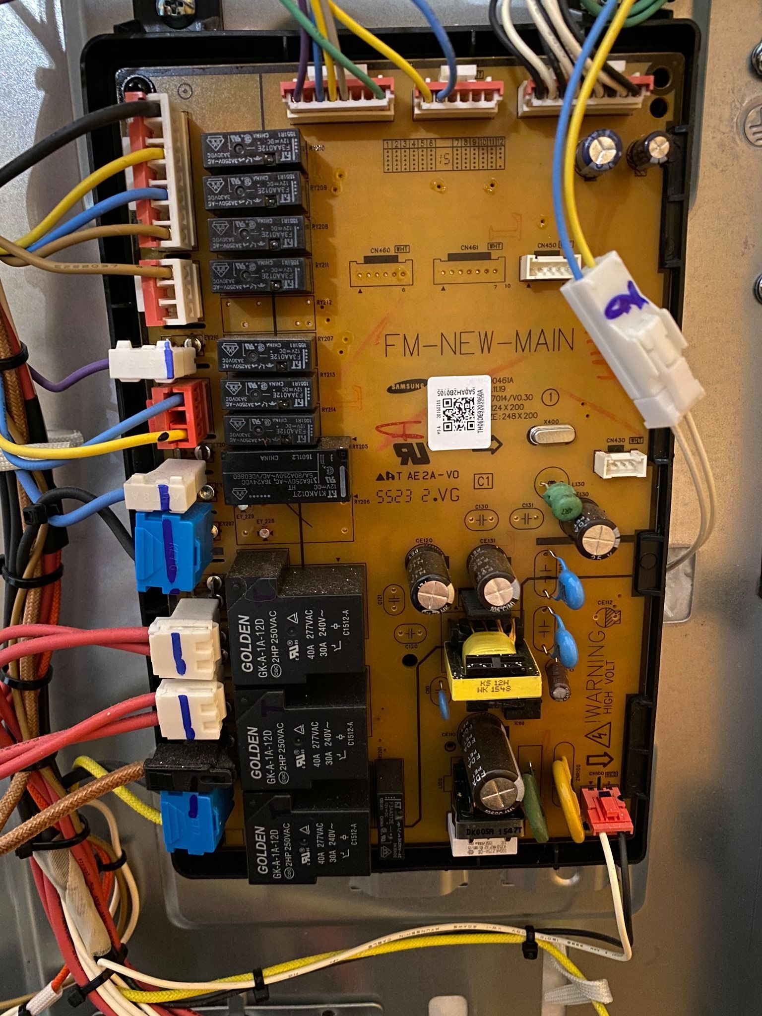 Circuit board with wires and relays, inside a metal enclosure.