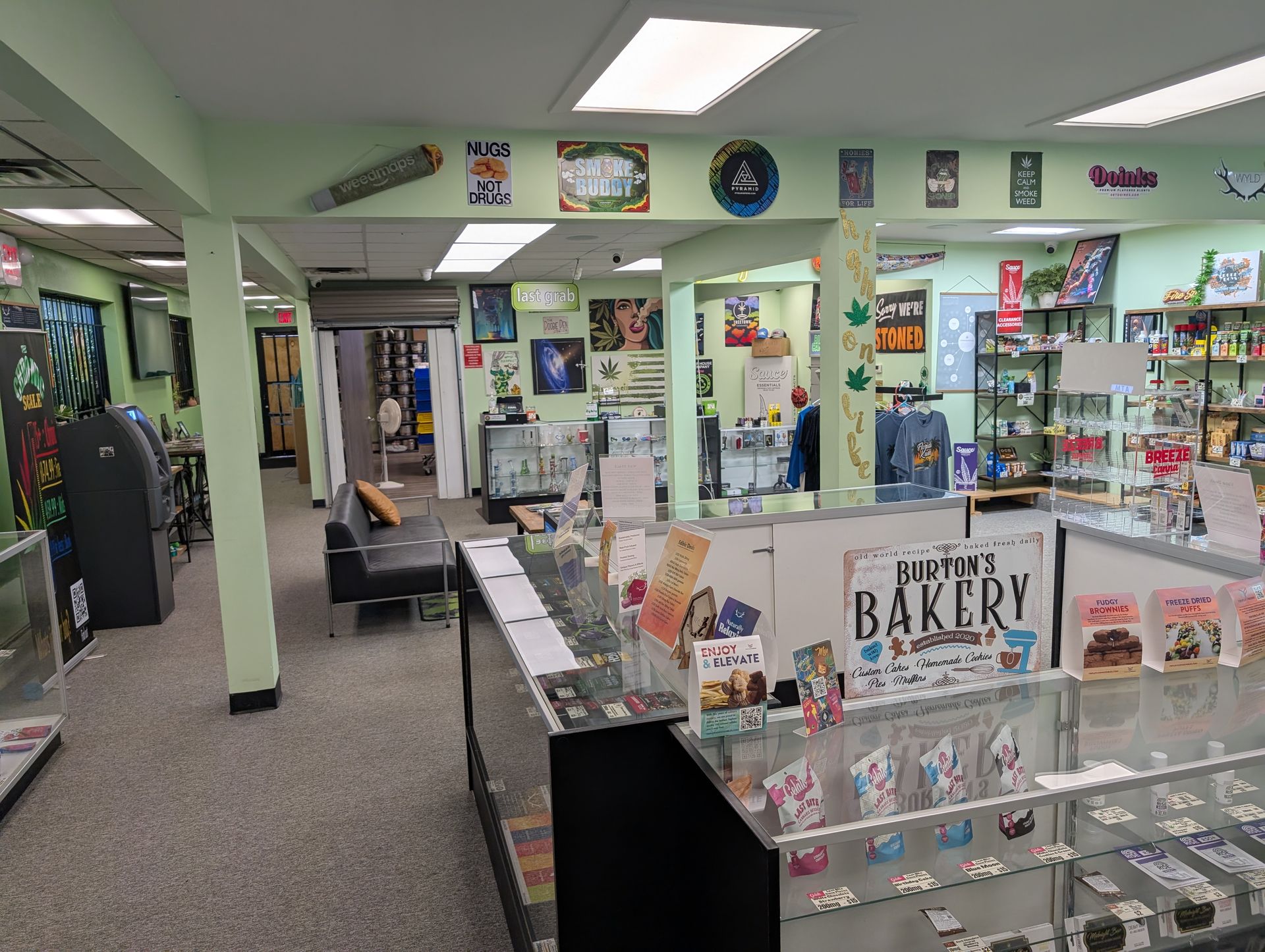Inside a shop with display cases, walls are green.