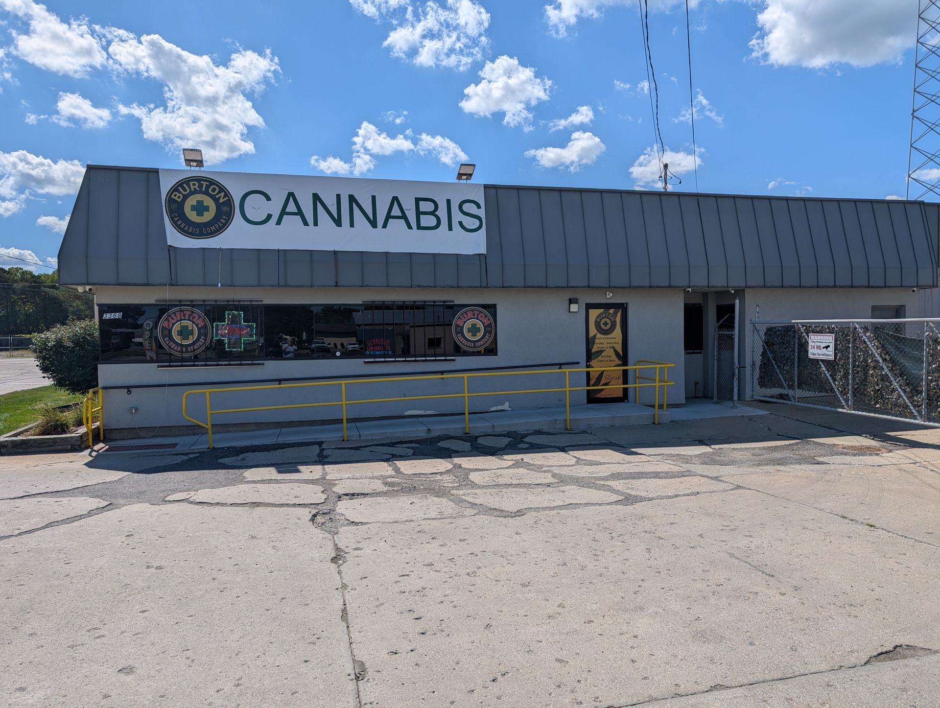 Cannabis dispensary with a dark facade, a yellow accessible ramp, and a sign that says 