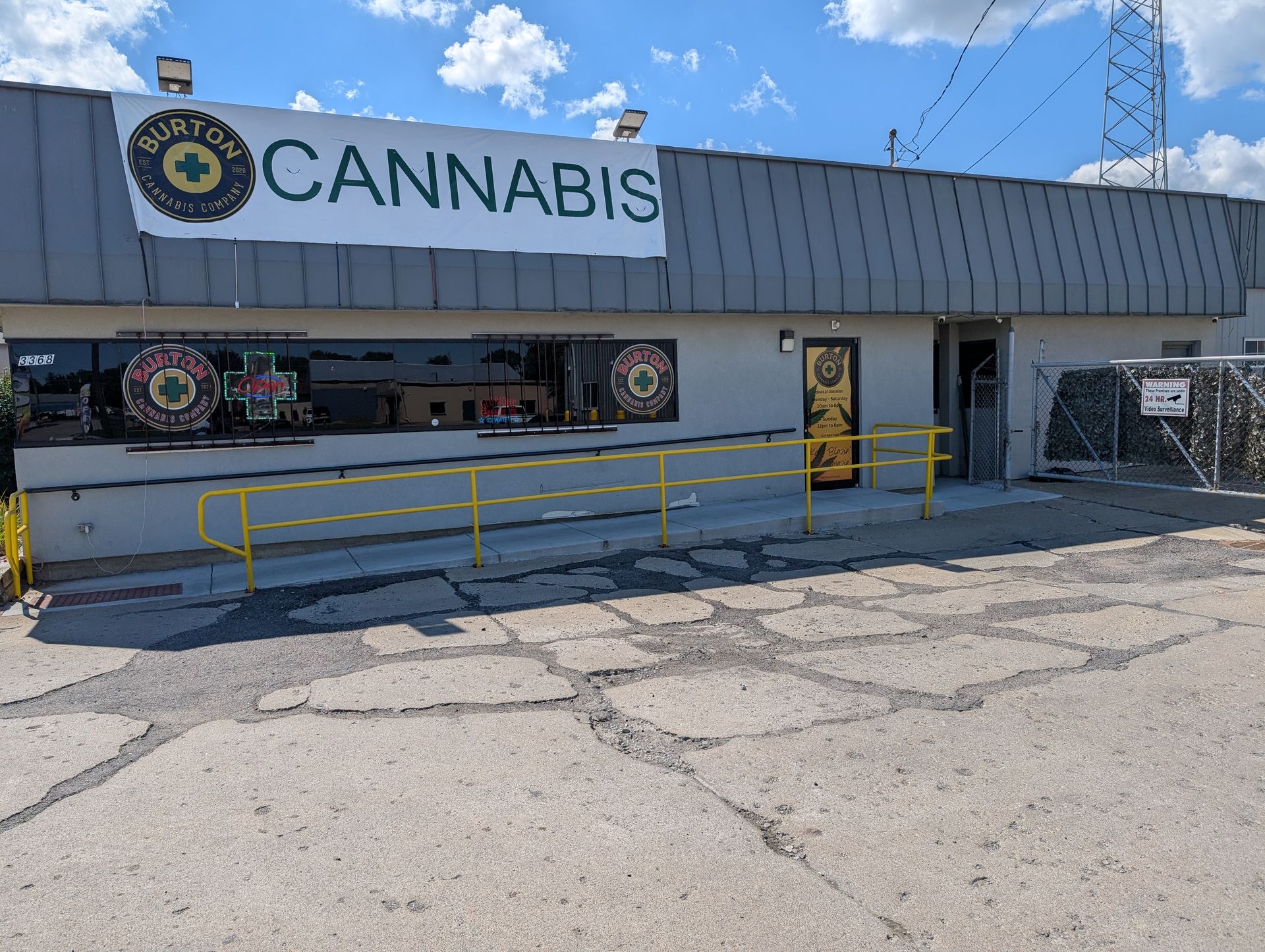 Exterior of Dayton Cannabis store: gray building with green and yellow sign, accessible ramp.