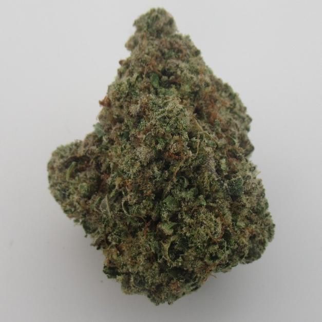 Bud of cannabis, green and tan with visible trichomes, against a white background.