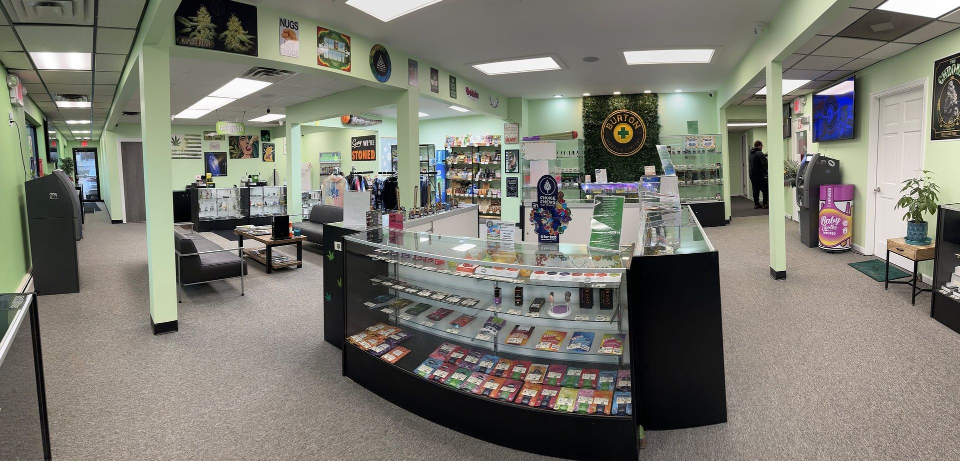 Interior of a cannabis dispensary with display cases, products, and a person in the back.