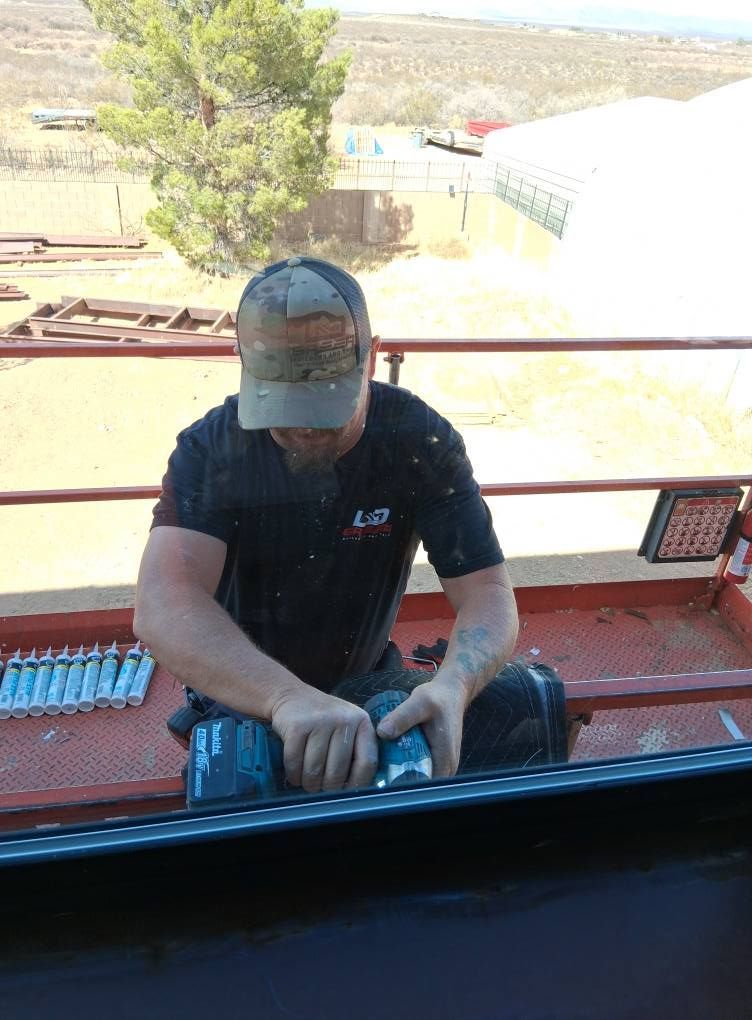 A man is working on a roof with a drill.