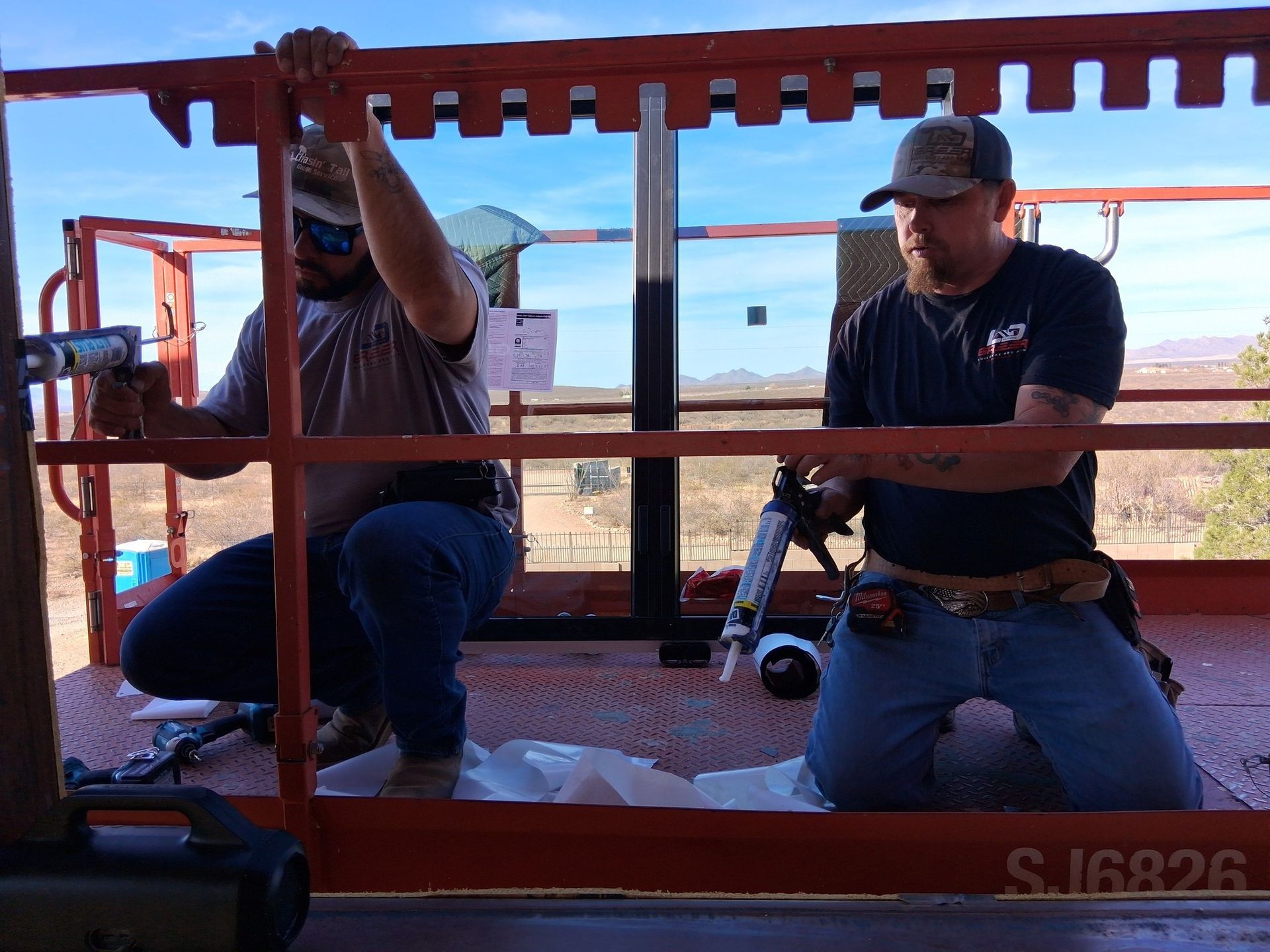 Two men are working on a crane with the number sj8826 on the side.